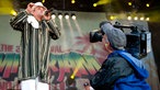Der Dub Inc Frontmann wird auf der Bühne vom Kamera-Team gefilmt