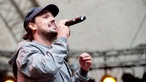 Die österreichische Band Iriepathie steht auf der Bühne. Frontmann "Professa" trägt eine graue Jacke und hält in der echten Hand das Mikrofon.