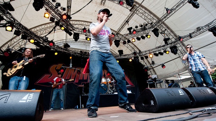 Eine 5 köpfige Rockformation steht auf der Bühne und gibt ein Lied zum Besten