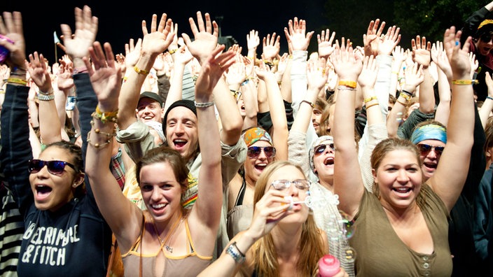 Alle Fans vor der Bühne heben die Arme in die Luft, bis auf ein Mädchen, dass unbedingt Seifenblasen machen muss. Smiley