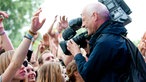 Ein Kameramann filmt die Besucher des Festivals während sie vor der Bühne stehen