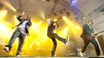 Madcon performen einen Song und werden von einem Gitarristen unterstützt. Beide Bandmitglieder haben ein Mikrofonin der Hand. Sie drehen sich jeweils von einander weg, beide haben einen Arm in der Luft