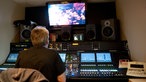 Der Regieraum des WDR-AUfnahemwagens. Ein Tonmischer sitzt vor seinem Mischpult und blickt auf den Mixer
