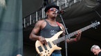 Bassist mit roter Brille und Hut am Mikrofon