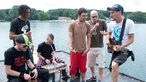 Eine Band spielt mit Akustikinstrumenten am Seeufer