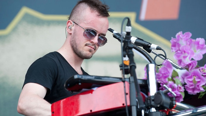 Ohrbooten-Keyboarder spielt auf Keyboard mit Blumen dekoriert.