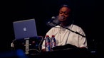 Mann am Synthesizer mit Macbook