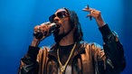 Snoopdog singt ins Mikrofon und hält eine Zigarette in der Hand