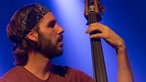Kontrabassist von Tim Vantol in der Nahaufnahme schaut auf sein Griffbrett