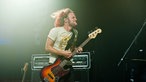 Der Sänger spielt mit ordentlich Power seine Gitarre, die Haare fliegen umher.