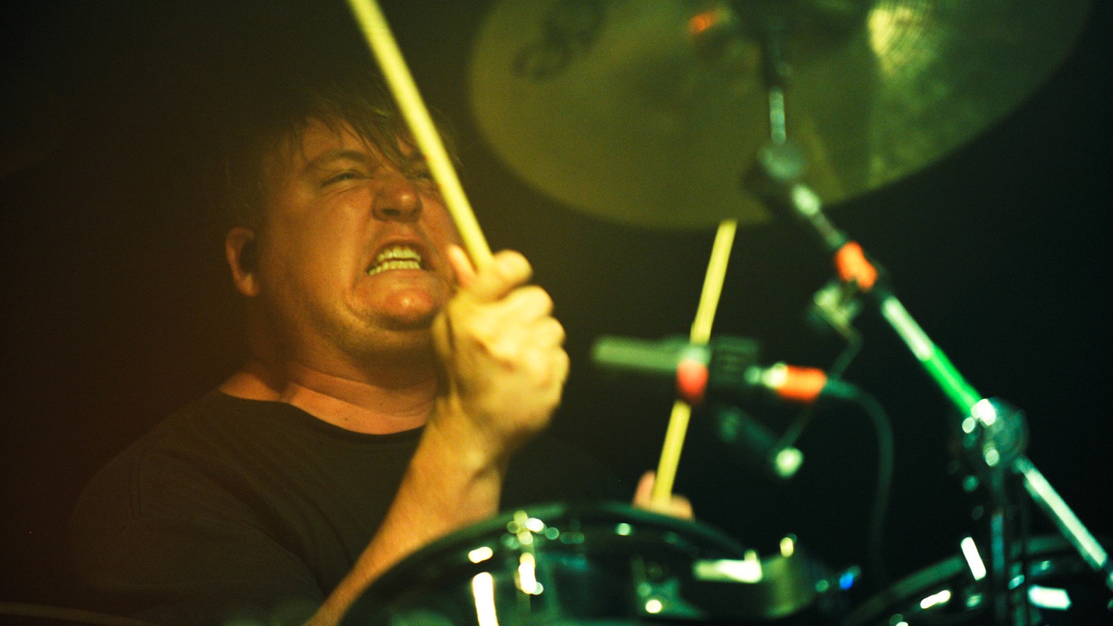 Die Anstrengung steht dem Drummer ins Gesicht geschrieben während er sein Instrument betätigt