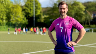Das Bild zeigt Daniel Aßmann auf einem Fussballplatz. Er trägt das Auswärtstrikot der deutschen Nationalmannschaft für die diesjährige EM.