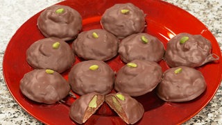 Lebkuchen mit Pistazienfüllung auf einem roten Teller.