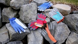 Aufnahme  vieler Paare von Gartenhandschuhen auf dicken Felssteinen