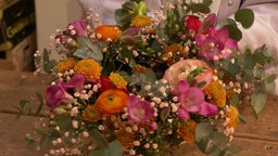 Das Bild zeigt einen farbenfrohen Osterkranz aus Blumen.
