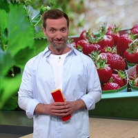 Daniel Aßmann befindet sich im Servicezeit-Studio. Im Hintergrund ist eine Abbildung von Erdbeeren zu sehen.