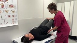 Das Bild zeigt zwei Frauen in einer Praxis. Es werden Beckenboden Übungen durchgeführt.