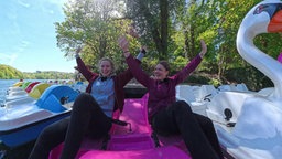 Die zwei Testerinnen auf einem pinken Trettboot.
