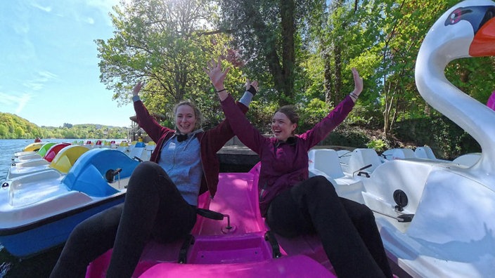 Die zwei Testerinnen auf einem pinken Trettboot.