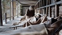 Filmstill aus dem Film "Formen moderner Erschöpfung". Drei Menschen auf der Terrasse eines Sanatoriums