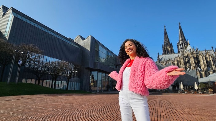 Frau steht auf Platz, im Hintergrung der Kölner Dom und das Museum Ludwig