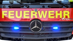 An einem Feuerwehrfahrzeug leuchten unter dem Schriftzug "Feuerwehr" zwei Blaulichter