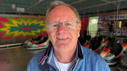 Mann vor Autoscooter