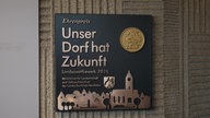 Das Bild zeigt eine Plakette mit einem Ehrenpreis.