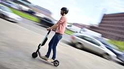 Das Bild zeigt einen Mann auf einem E-Scooter.