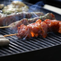 Unterschiedliche Arten Fleisch liegen auf einem Grill