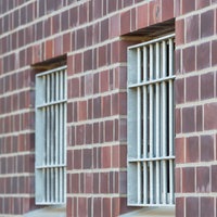 Drei vergitterte Fenster einer JVA in Düsseldorf