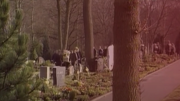 Große Trauergesellschaft auf einem Friedhof