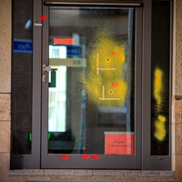 Auf einer Tür aus Glas wurden Einschusslöcher markiert.