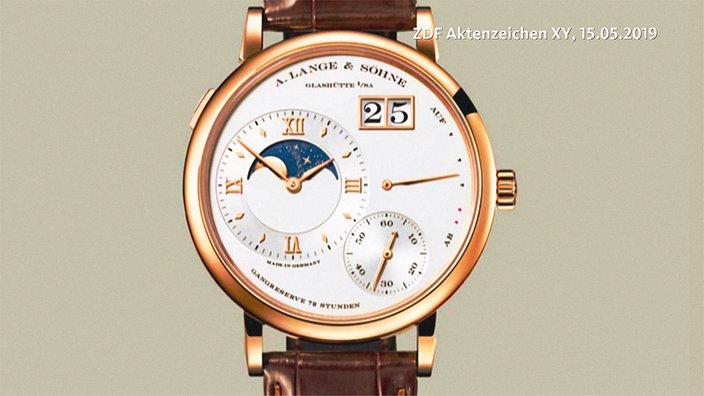 Eine in Gold gefasste Armbanduhr mit braunem Lederband und hellem Zifferblatt des Fabrikats A. Lange und Söhne.