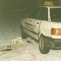 Taxi, in dem ein Mann 33 Mal auf eine Taxifahrerin einstach. Neben dem Taxi sind auf dem Boden Spurenmarkierungen der Polizei