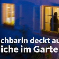 Eine Hauswand mit zwei Fenstern. Im Haus brennt Licht und im rechten Fenster steht ein Schatten.
