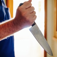 Ein Mann hält ein großes Messer in der Hand