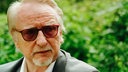 Nahaufnahme von Willi Erdmann, einem älteren Mann mit weißen Haaren und Brille.