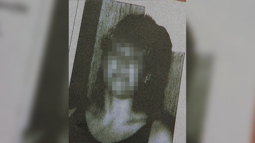 Ein schwarz-weiß Foto einer Frau. Ihr Gesicht ist zensiert und nicht zu erkennen.