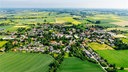 Eine Luftaufnahme von Ostönnen in Soest. Einige Häuser und Straßen, viele Böumen und umliegende Felder.