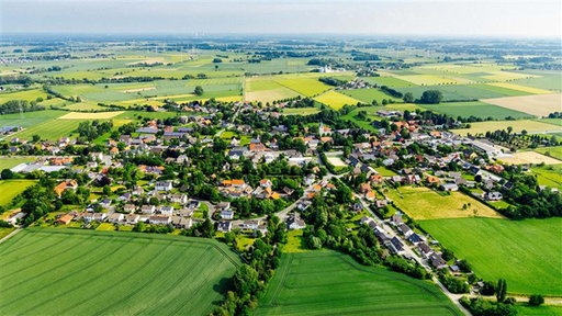 Eine Luftaufnahme von Ostönnen in Soest. Einige Häuser und Straßen, viele Böumen und umliegende Felder.