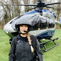 Lisa Ocklenburg steht vor einem Helikopter. Sie lächelt.