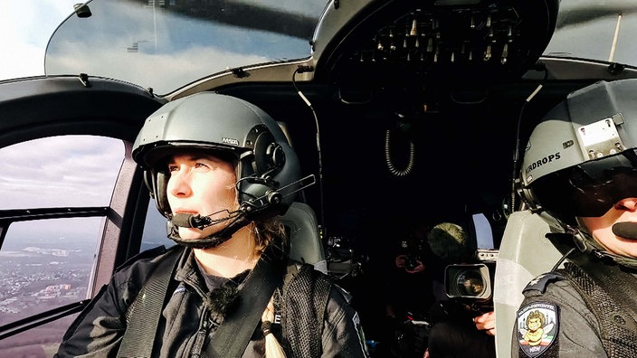 Lisa Ocklenburg sitzt im Cockpit des Helikopters, neben ihr der Co-Pilot.