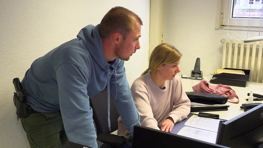 Die Ermittler Julius Mergelkamp und Nicole Fischer-Kentschke von der Polizei Recklinghausen gucken in einem Büro auf einen Computermonitor