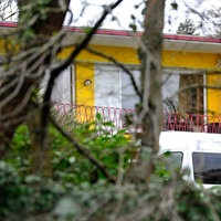 Durch Bäume ist das Wohnhaus des getöteten Unternehmer-Paars zu sehen