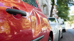 Ein parkendes Auto mit einer Delle.