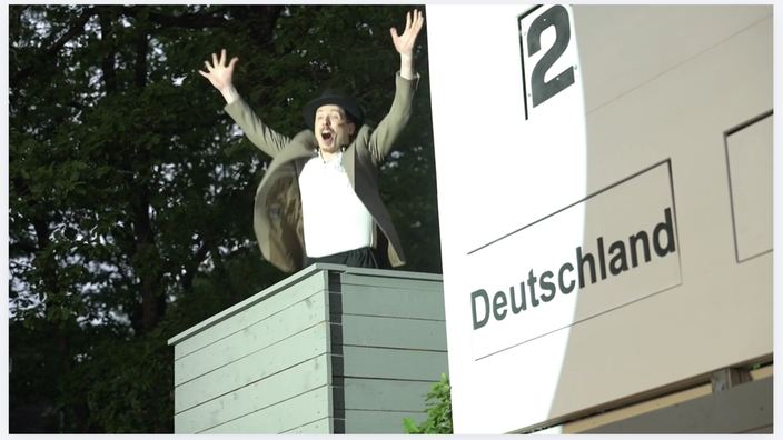 Das Bild zeigt die Stadionanzeige und den Kommentator im Wunder von Bern auf der Freilcihtbühne Hallenberg