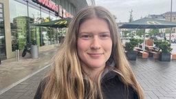 Junge Frau schaut freundlich in die Kamera