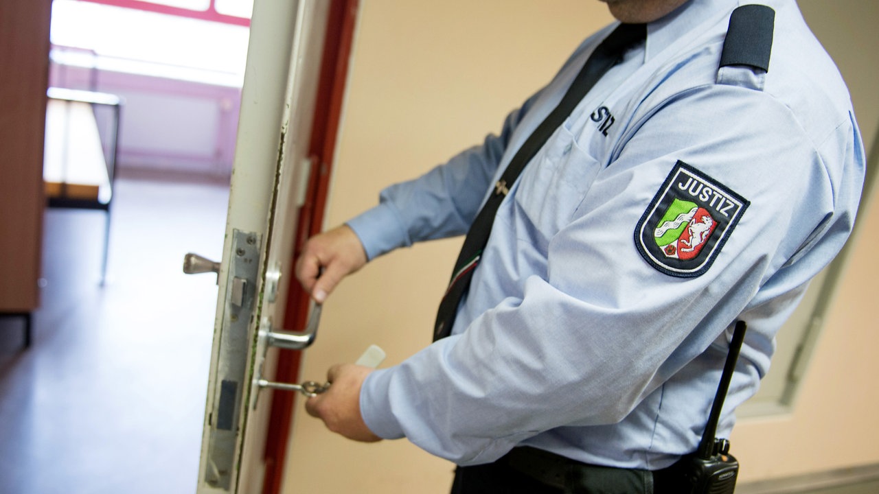 Ein Justizvollzugsbeamter schließt in der Justizvollzugsanstalt eine Tür