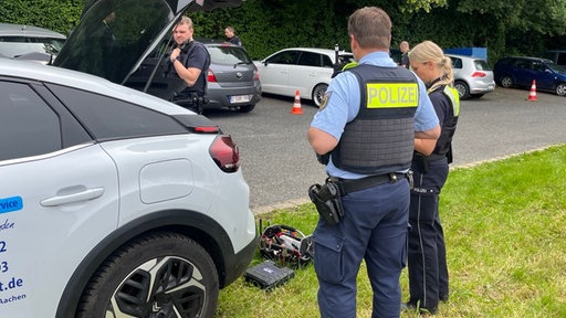 Zwei Polizeibeamte kontrollieren ein Fahrzeug an der belgischen Grenze